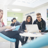 Students looking at laptop and notes 