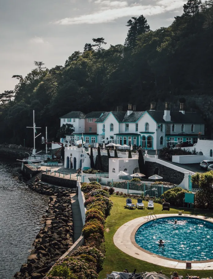 A view of a hotel in Portmeirion Village, next to the sea.