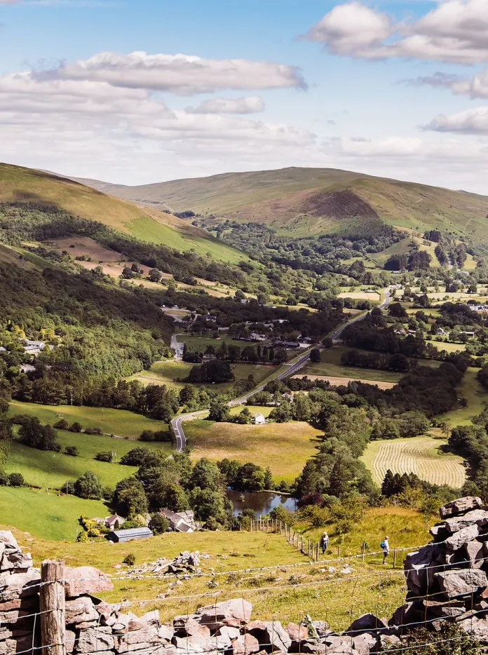 Stone wall with countryside and hills in background.