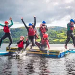 Children jumping off a float in the water.