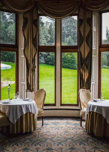 Tische im Restaurant mit Blick auf einen grünen Garten