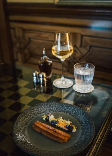Ein Teller mit Essen sowie ein Glas Wein und ein Glas Wasser