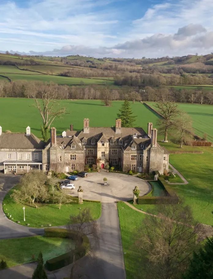 A view of the exterior of the hotel surrounded by countryside.