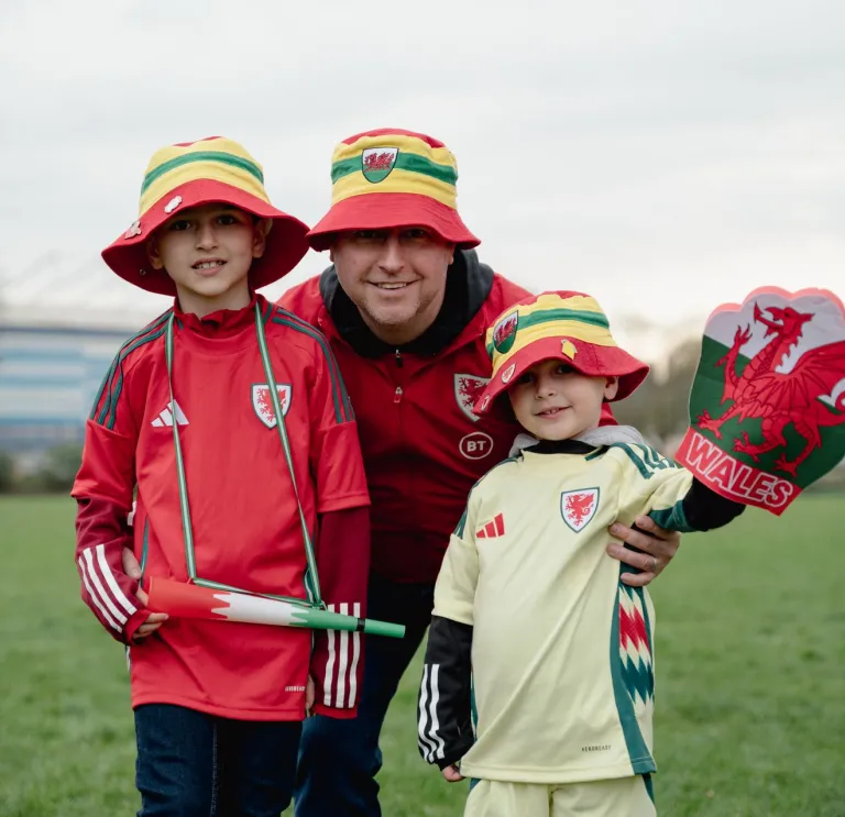 Trois personnes sourient à la caméra en portant des chapeaux seau gallois.