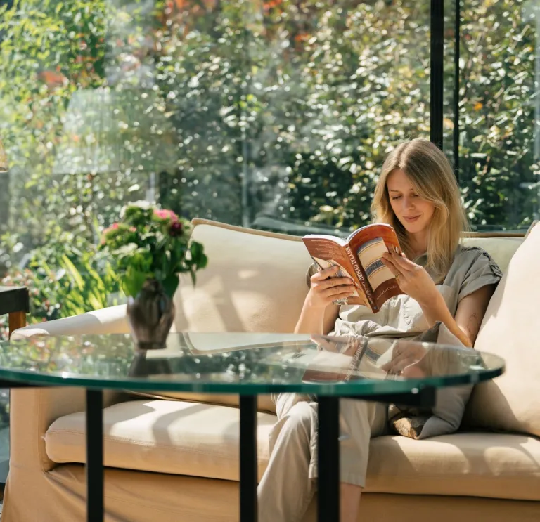 A person sitting on a sofa reading a book.