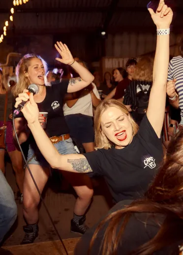 A group of people singing and dancing at a festival