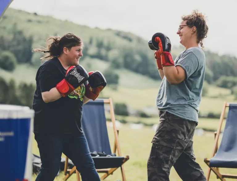 Two womxn sparring in a festival tent