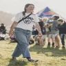 a photograph of Camp VC founder Gemma Harrison walking across a field at Camp VC holding a megaphone