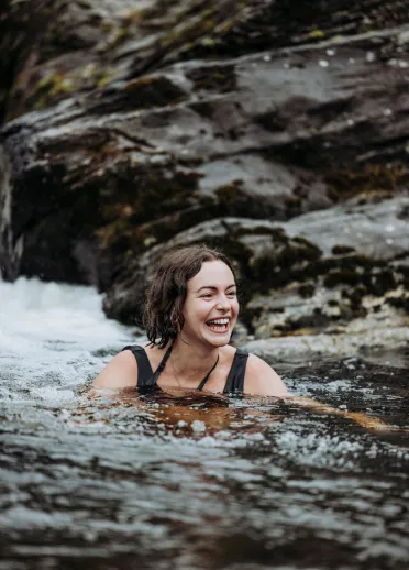 A photograph of a person swimming in a stream
