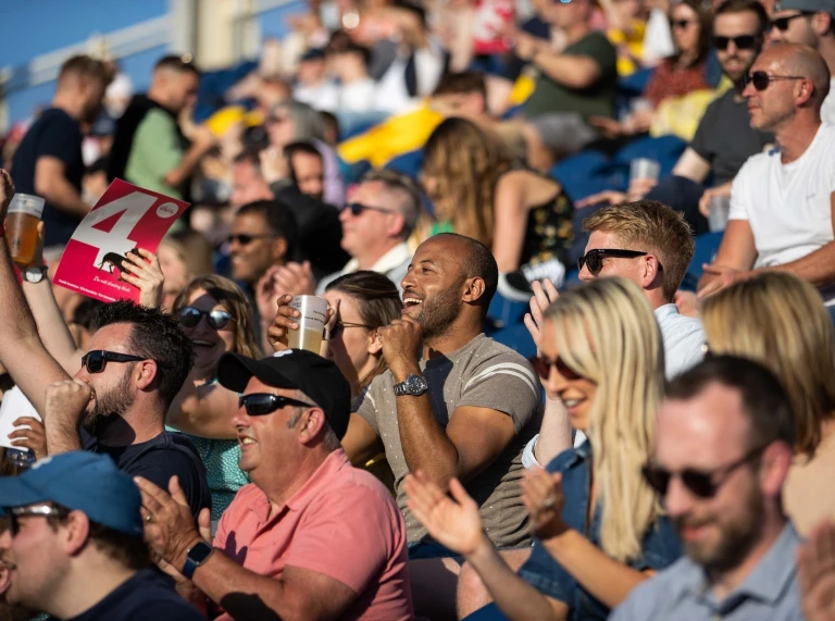 A crowd of people watching the cricket