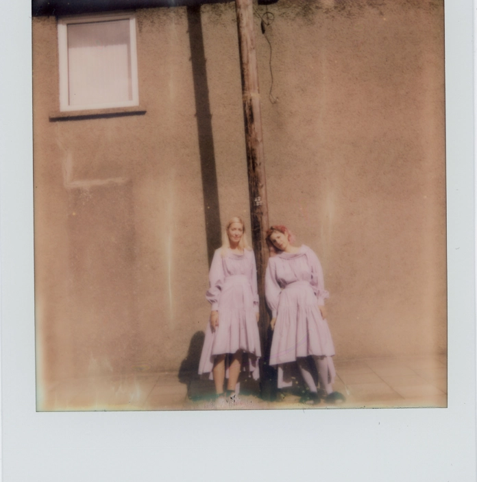 Two people standing in front of a house