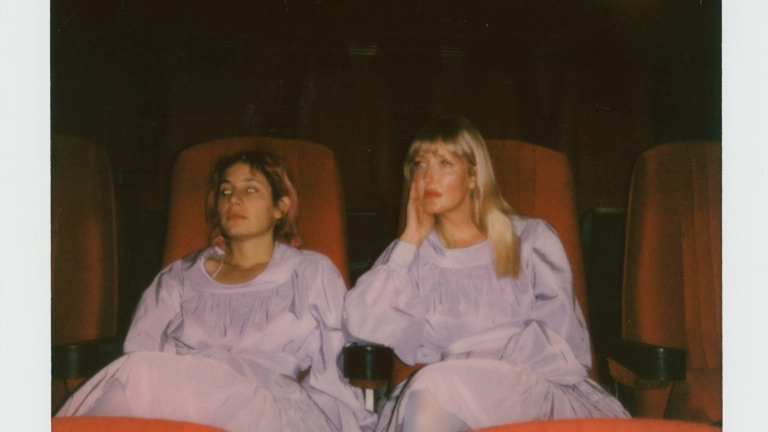 Zwei Personen sitzen auf Stühlen