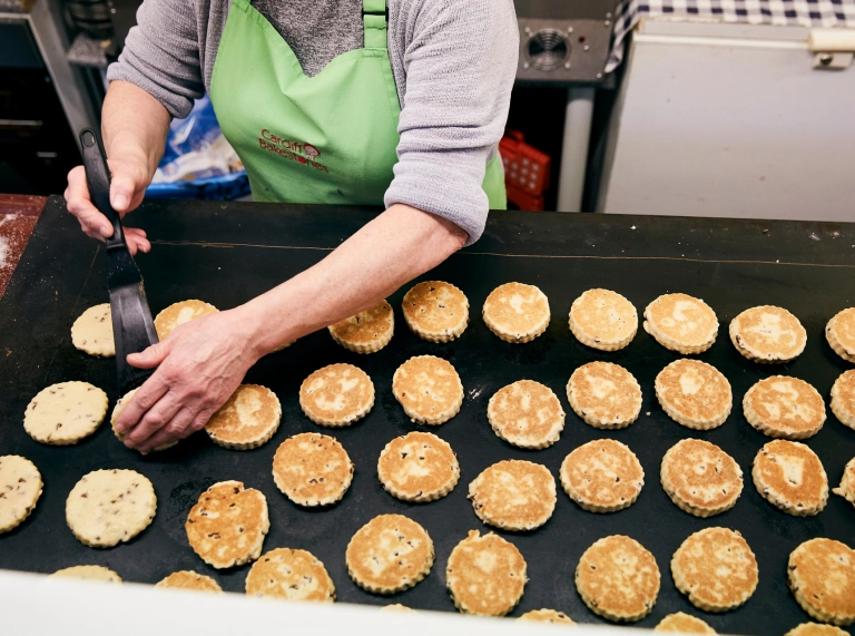 Welsh Cakes, die auf einer großen Grillplatte gebacken werden.