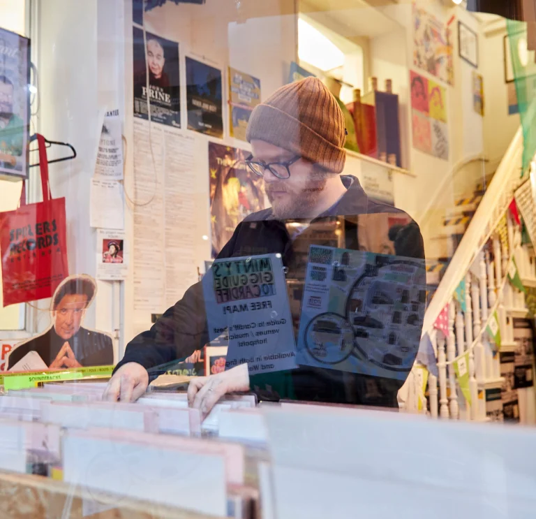 Huw Stephens schaut sich Schallplatten bei Spillers Records in einer von Cardiffs viktorianischen Arkaden an