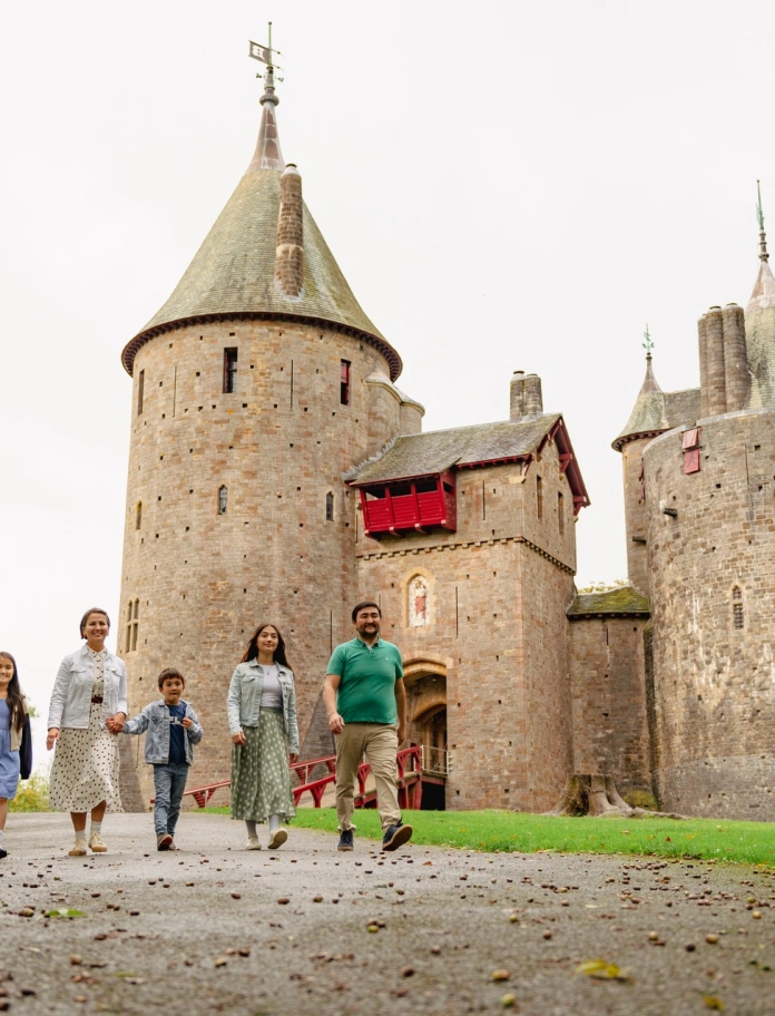family walking outside castle with turrets.