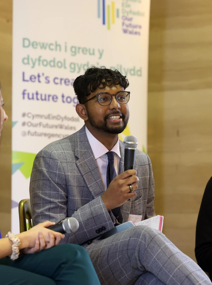 Three people sitting on chairs and talking on microphones 