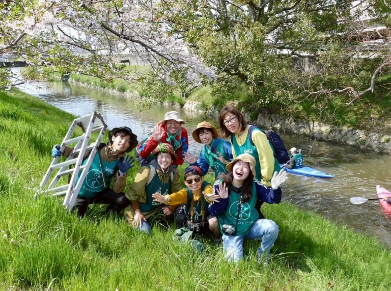 A group of people next to a river.
