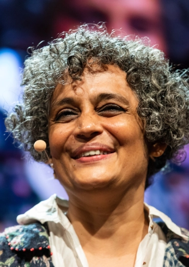 Headshot of a smiling lady wearing a presenter microphone and giving a talk. 