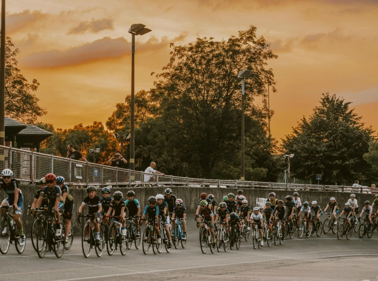Cyclists on a outdoor cycling track with sunset in the sky