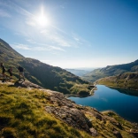 A scenic lake surrounded by large green mountains