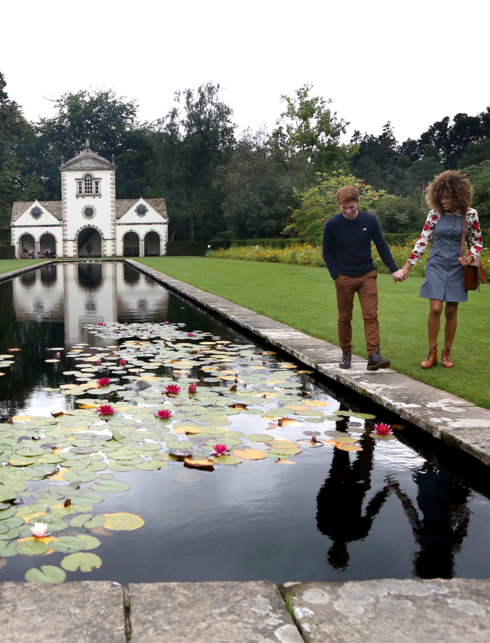 Couple walking by pond at Bodnant Garden