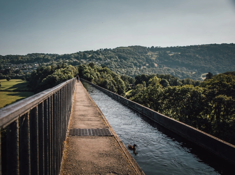 Un acueducto angosto ubicado en lo alto sobre un paisaje verde