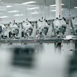 Robots alineados a lo largo de un banco de trabajo en un entorno técnico de fábrica impecable.