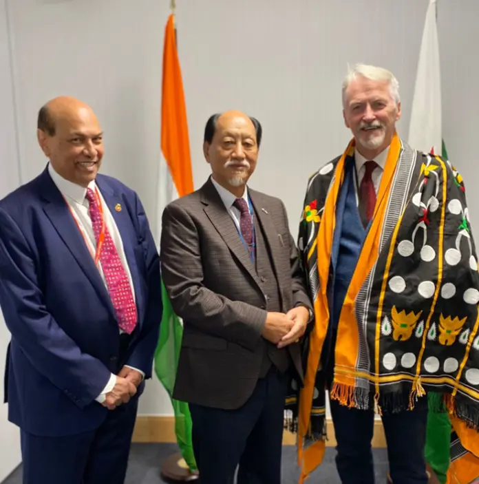 Three men stood in suits smiling