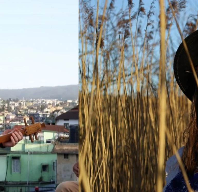 Man with small instrument and women in fields of hay 