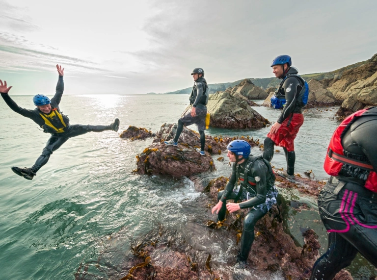 Un groupe d'hommes fait du Coasteering près de St Davids, Pembrokeshire
