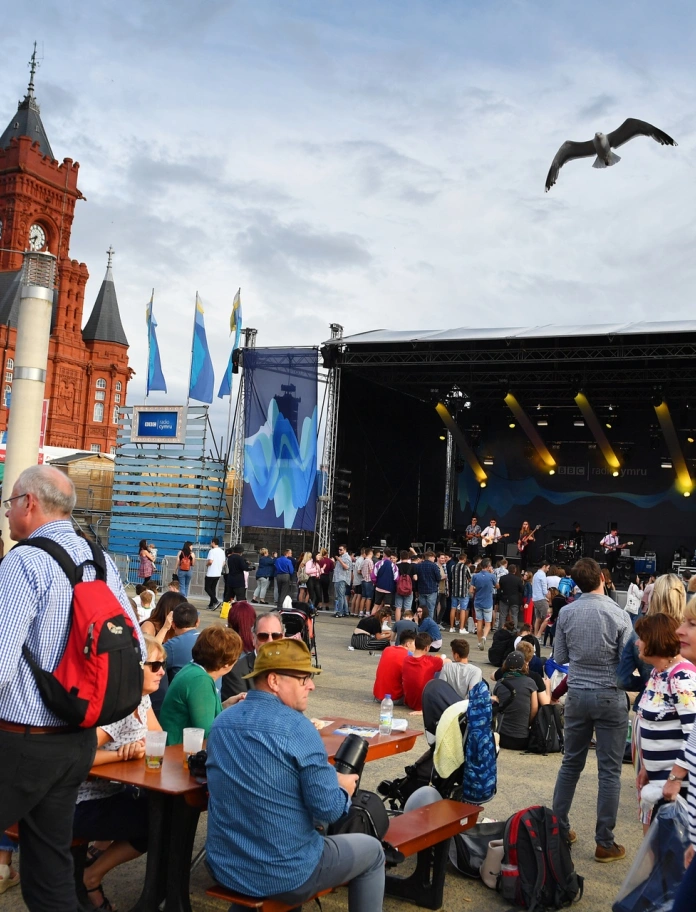 Un groupe jouant sur une scène et une foule les regardant