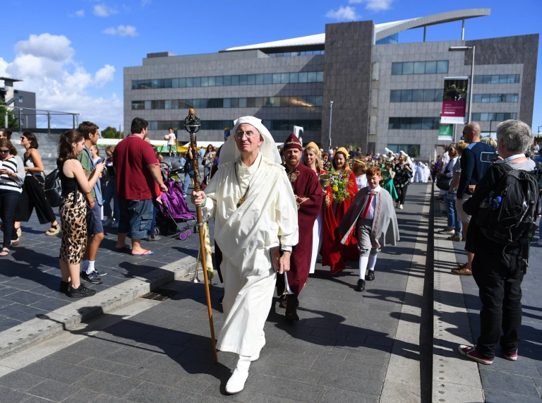 Des personnes marchant dans une foule en costume.