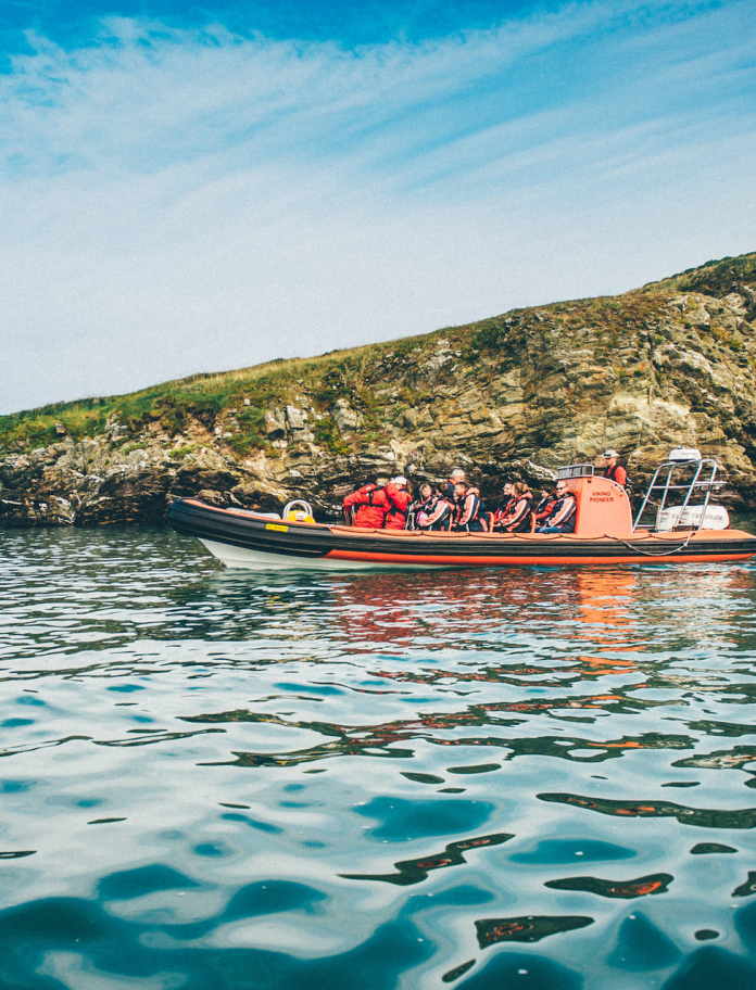 Boat of people at sea dolphin spotting off Ramsey Island, Pembrokeshire, South West Wales