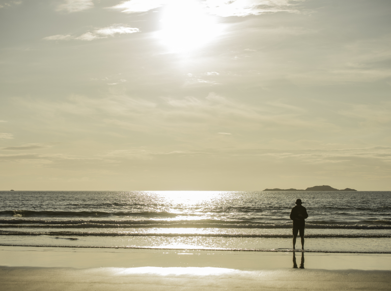A man with Whitesand's Bay in the foreground.