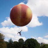 peach coloured balloon with performer below