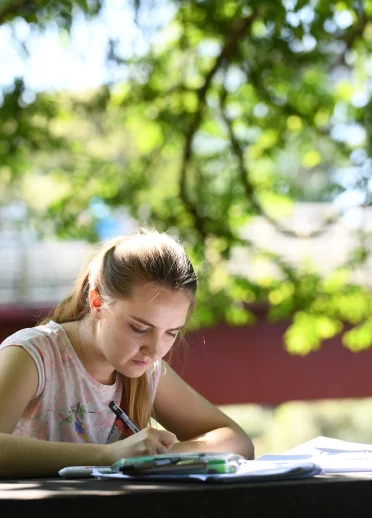 Girl studying on a bench in Bute Park, Cardiff