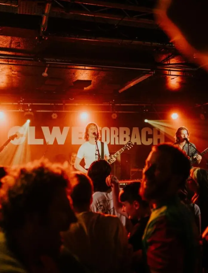 A band playing on stage in front of an excited crowd.