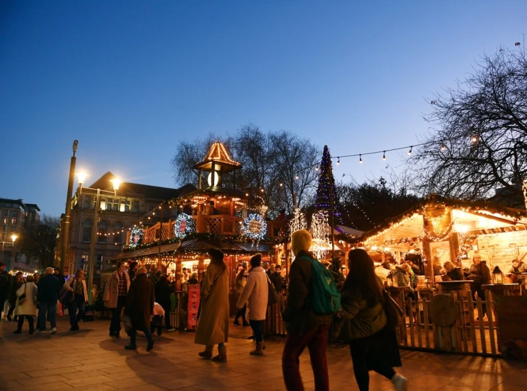 A brightly lit street market by dusk light