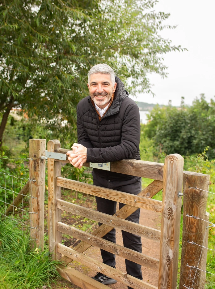 Derek Walker standing by a gate.