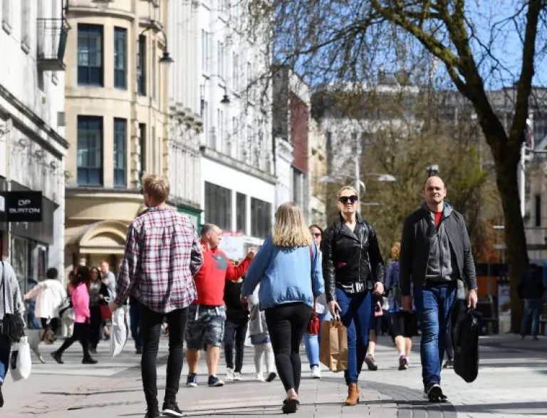 shoppers walking along busy street.