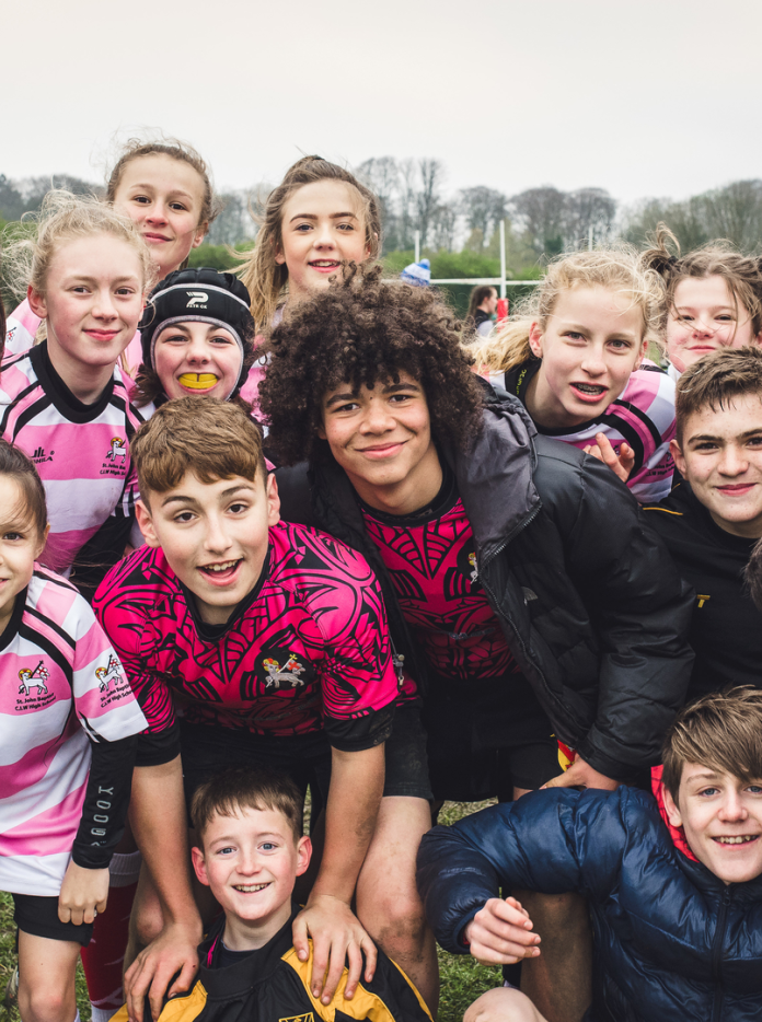 Un grand groupe de personnes souriantes face au caméra.