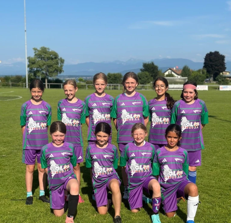 The young Swiss female football team standing on the pitch.