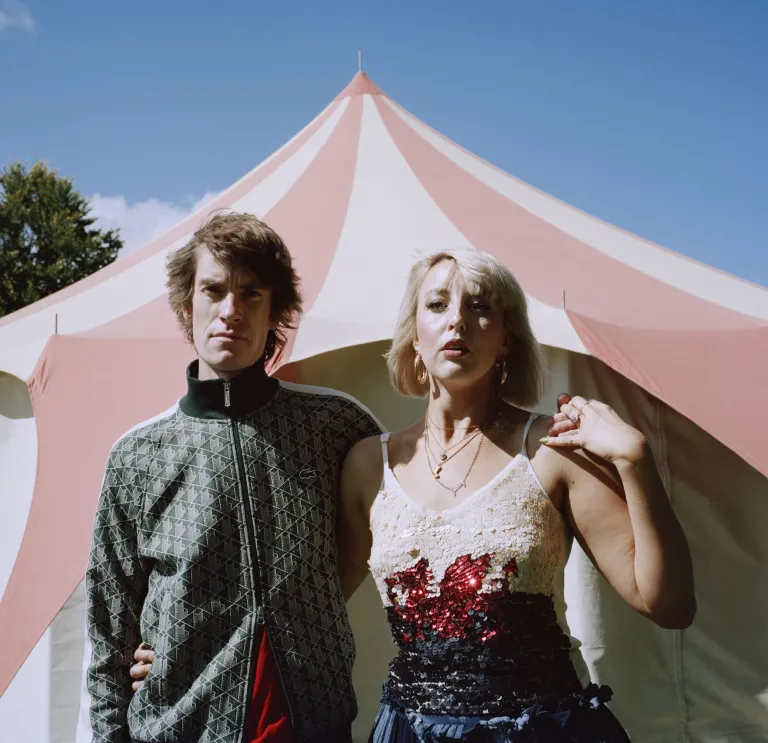 Two people standing in front of a tent.