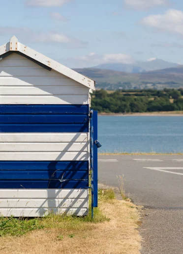 Cabane de plage rayée bleue et blanche sur le détroit de Menai