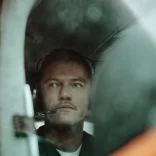 Luke Evans in small plane with headset, ready for takeoff