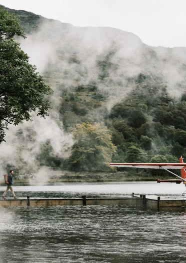 Luke Evans walking to a  small plane at the end of pontoon through fog